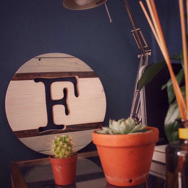 Customisable round wooden sign displaying the letter F